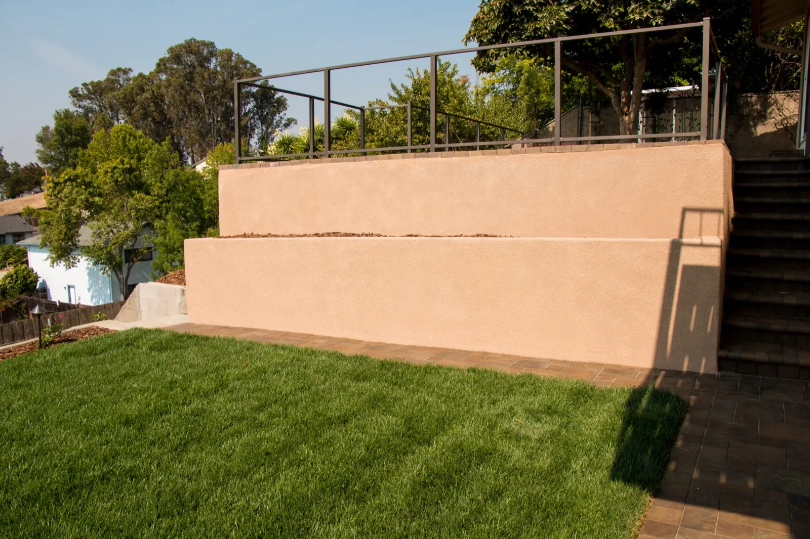 After — Aging block wall → tiered stucco walls and a level lawn in Benicia