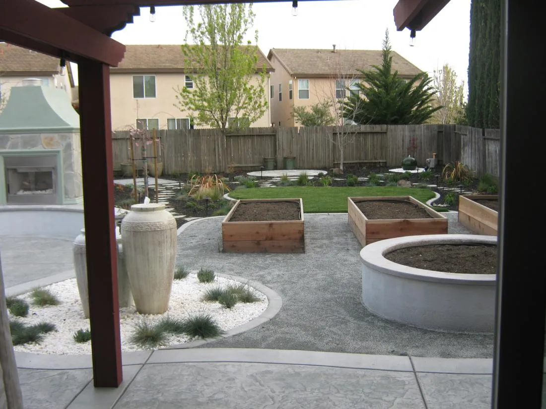 After — Dixon backyard: bare lawn → fireplace, raised beds & entertaining patio in Dixon