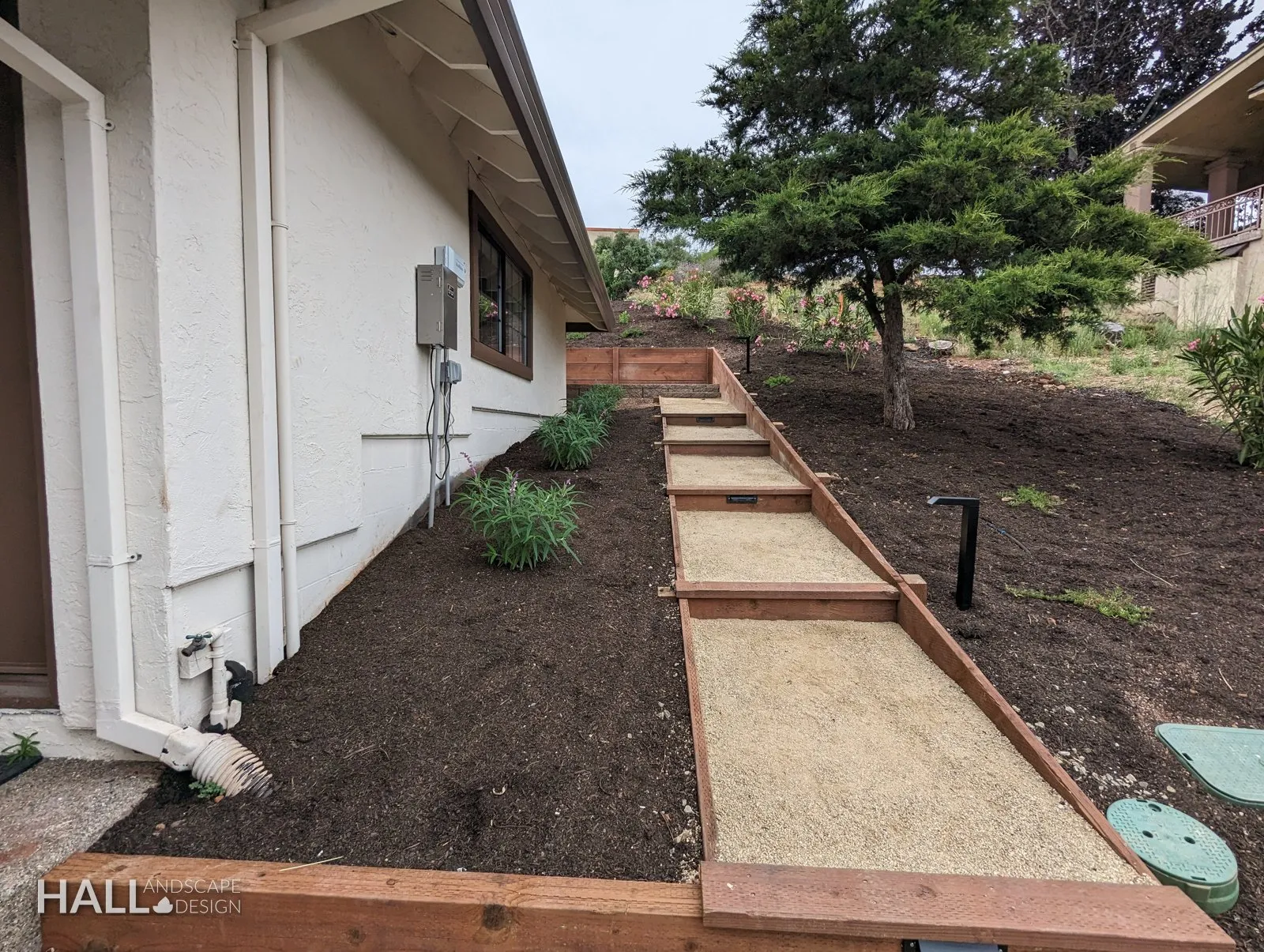 After — Dirt side yard → gravel path with timber terraces in Fairfield
