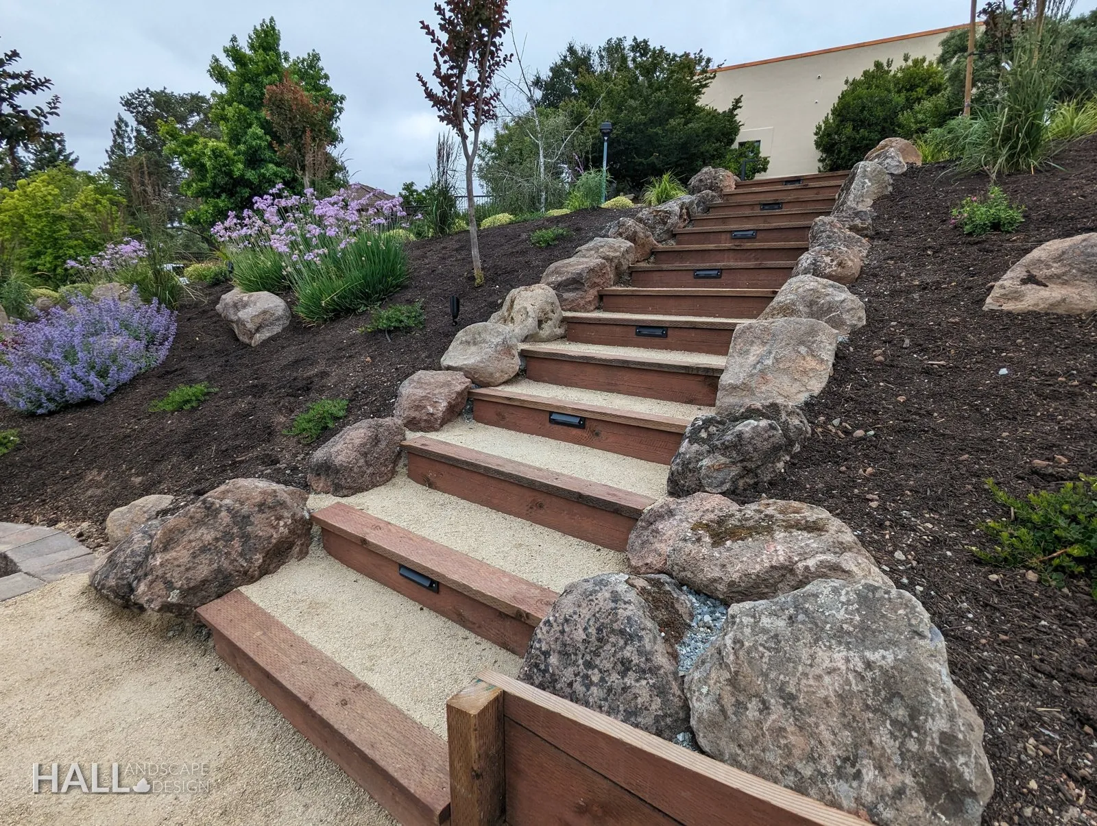 After — Green Valley slope: weedy steps → boulder-lined stairway with lit timber risers in Fairfield