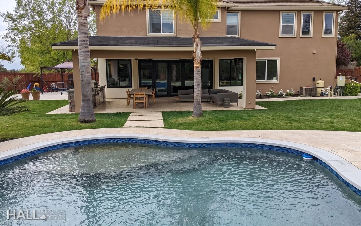 After — Plain stucco backyard → covered patio, palms & pool in Fairfield