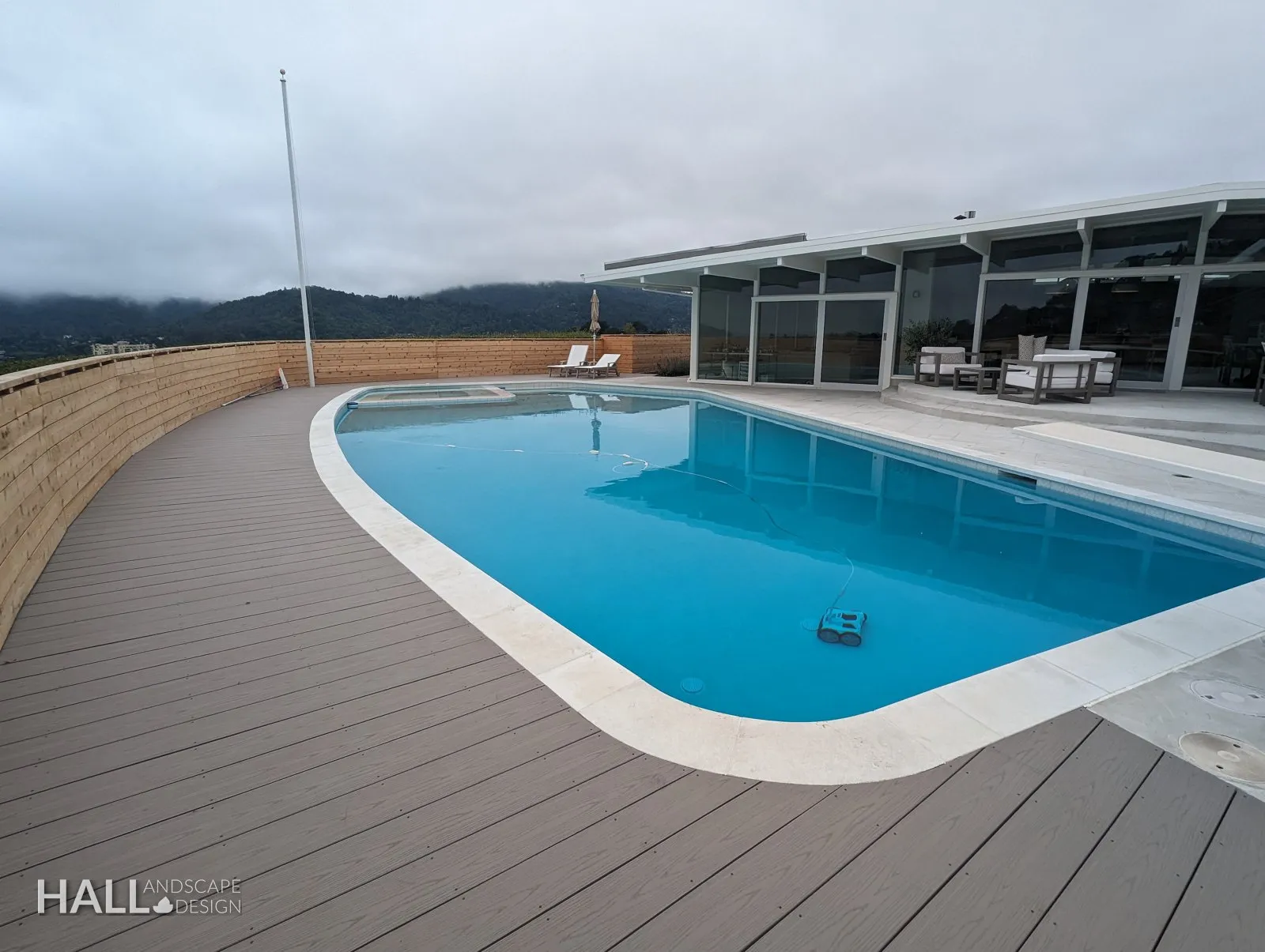 After — Faded redwood deck → grey composite deck & cedar fence around the pool in Greenbrae