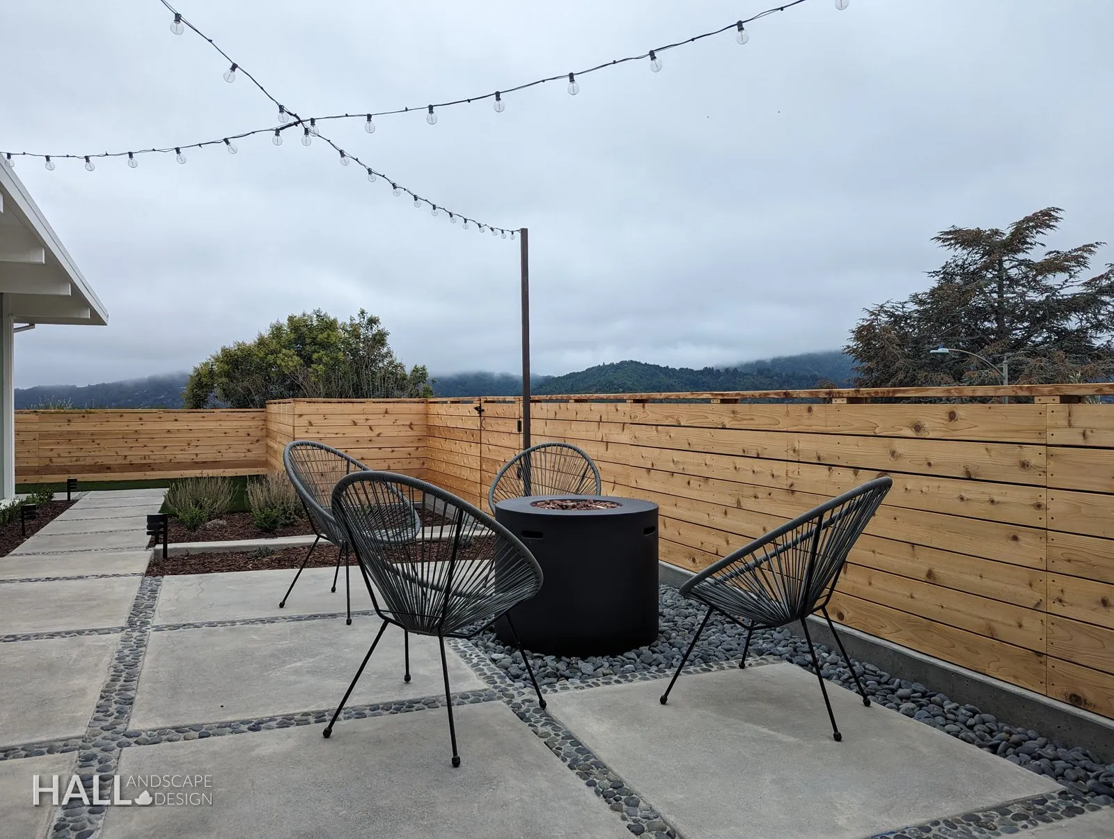 After — Plywood & rubble → string-lit courtyard with a fire pit in Greenbrae