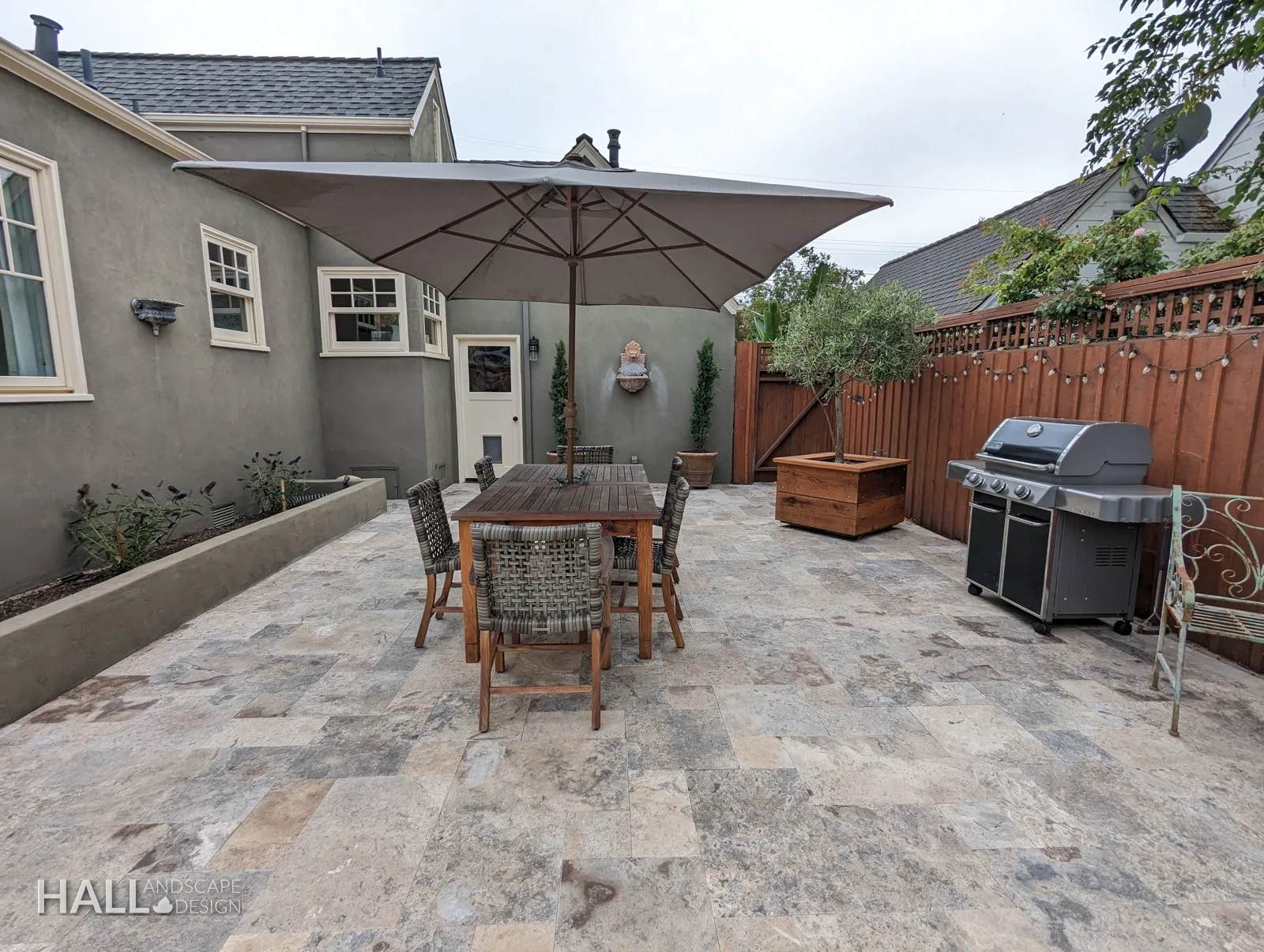 After — Tired paver patio → travertine dining terrace & grill station in Healdsburg
