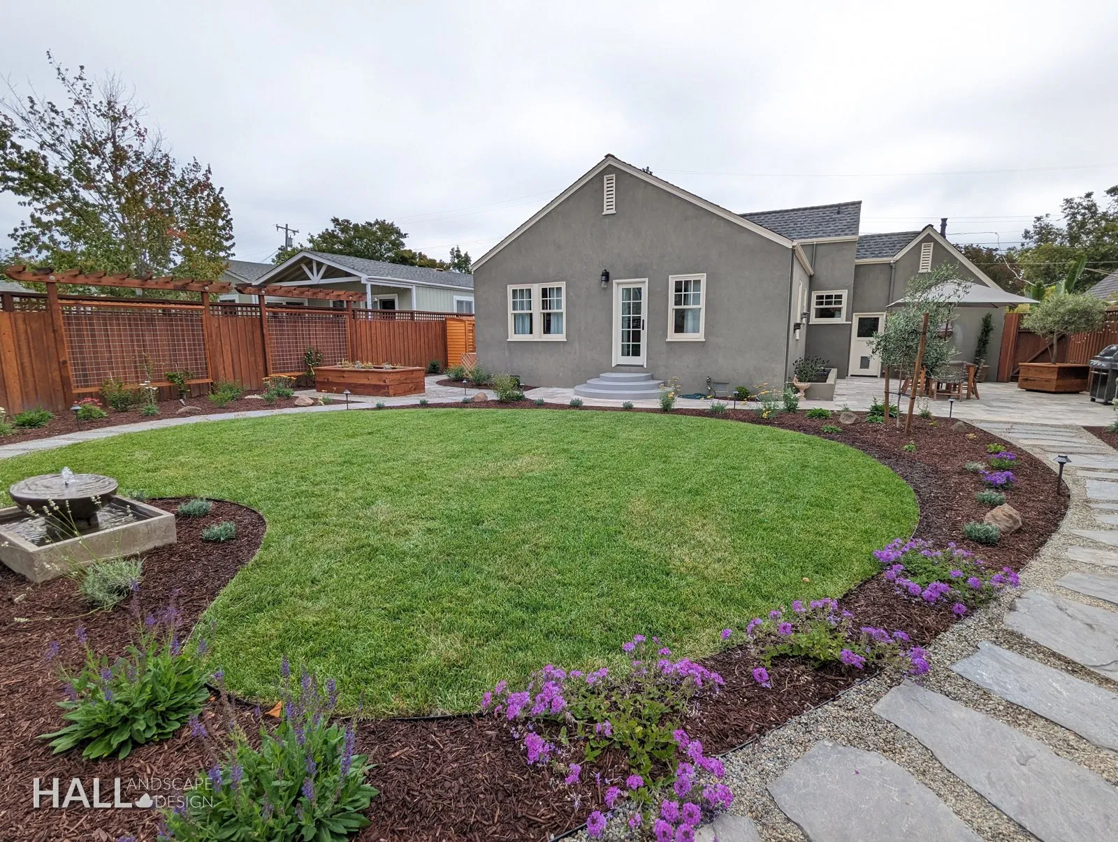 After — Dirt yard → circular lawn, flagstone path & flowering border in Healdsburg