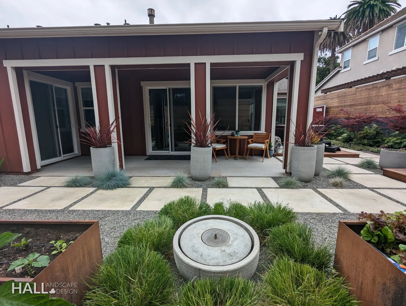 Bubbler fountain: Cast stone in a bed of grasses, water at grade. A finished Hall Landscape Design garden in Napa, California.