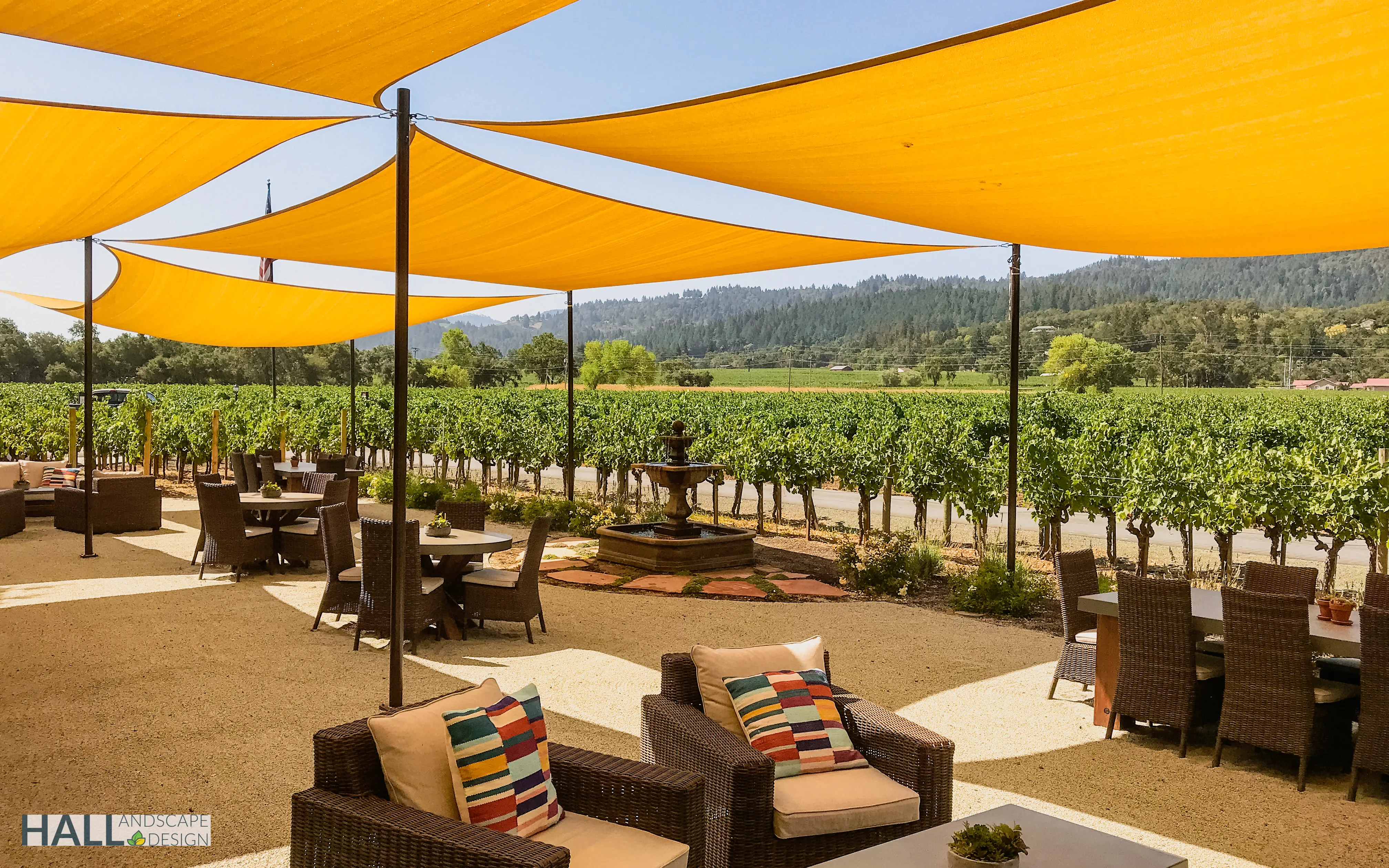 Winery terrace with orange shade sails and a fountain overlooking Napa Valley vineyards