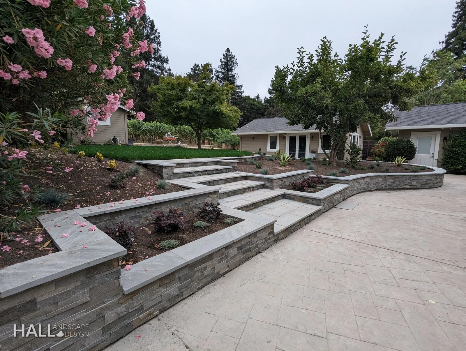 After — Tumbled boulders & agapanthus → tiered stone walls along the drive in San Rafael