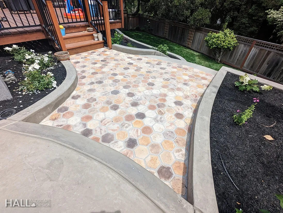 After — Sausalito: bare slope below the deck → mosaic paver terrace in Sausalito