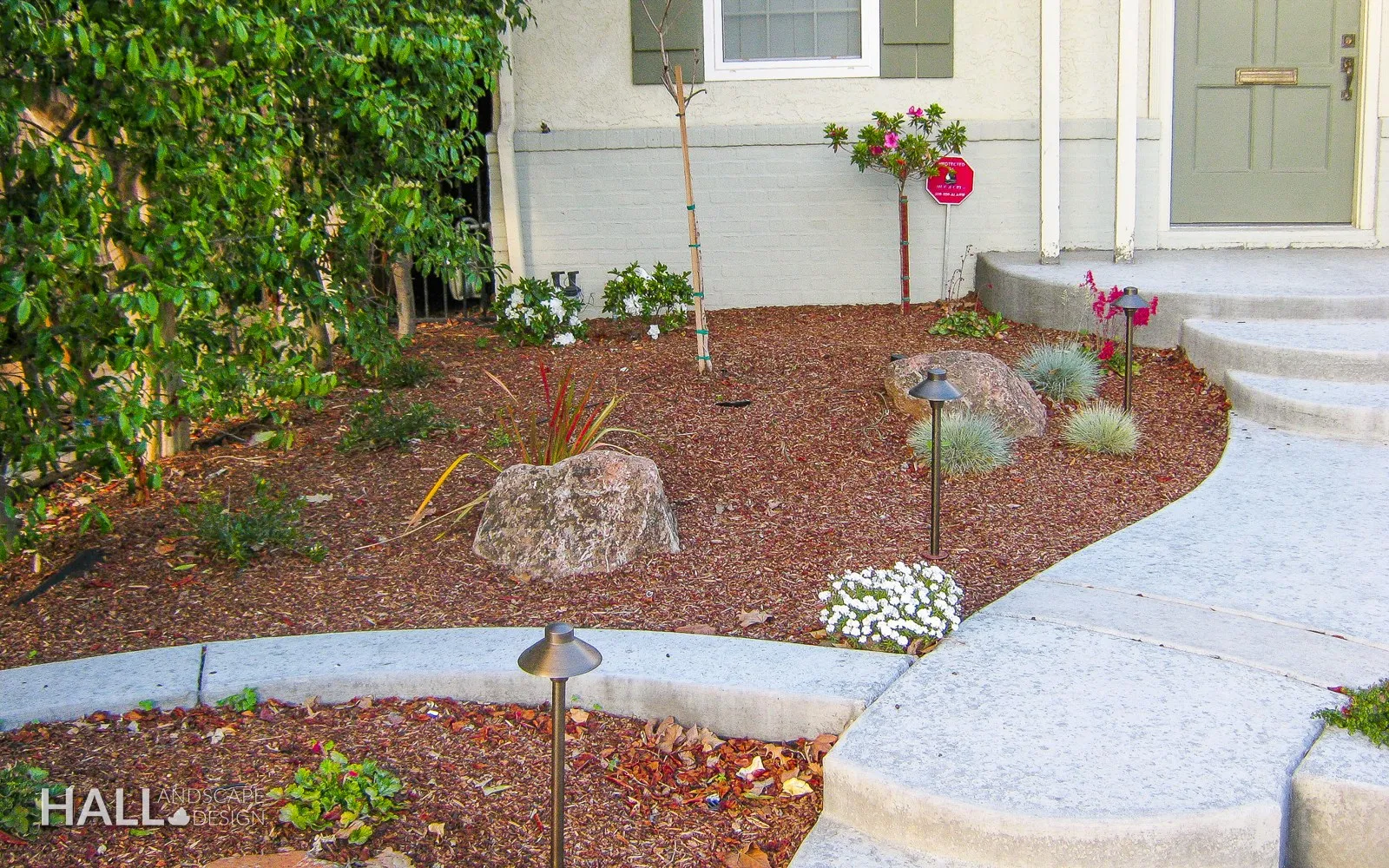 After — Lawn at the side entry → mulched bed with boulders & a stone walk in Vacaville