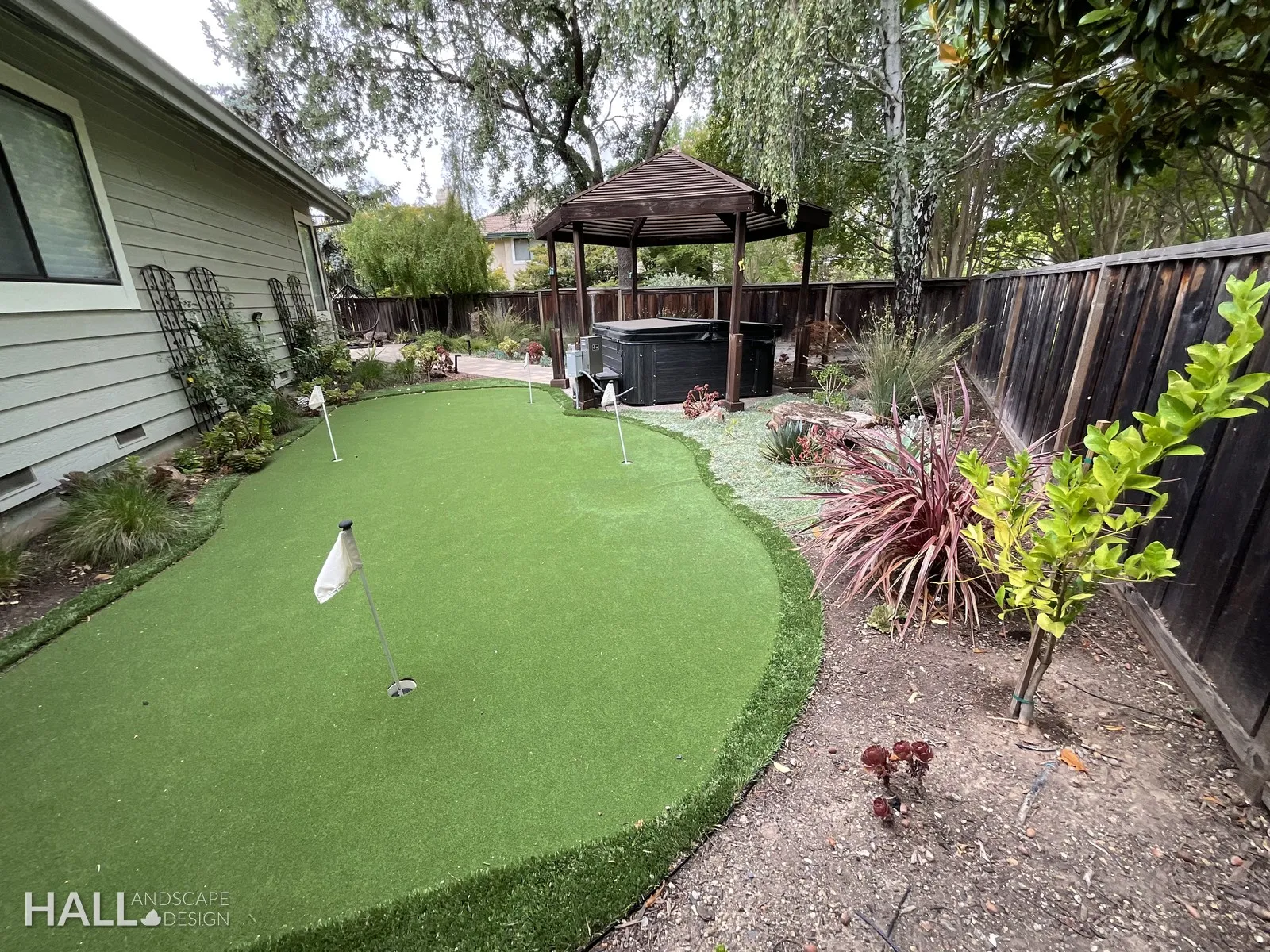 After — Gravel corner → putting green wrapped in flax & new trees in Yountville